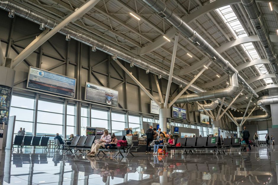 Pasajeros esperando en una terminal de aeropuerto moderna y luminosa