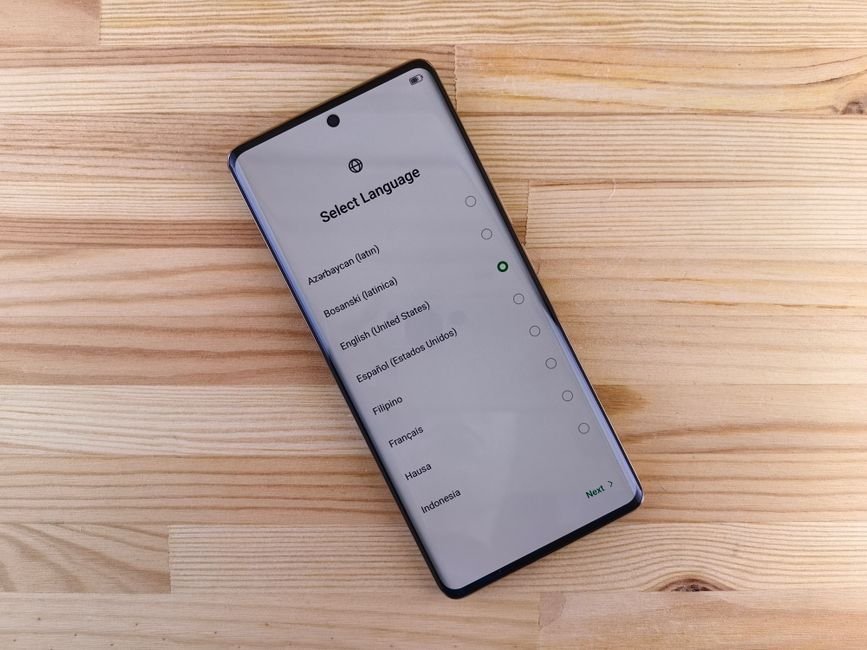 Un smartphone posé sur une table en bois, une liste de réglages à l’écran