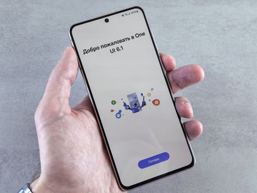 A hand holding an Android smartphone showing the settings screen