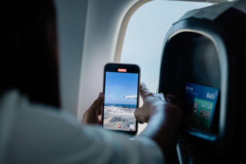 A traveller checks their smartphone in an airport departure lounge